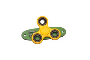 Żółty spinner do tablicy sensorycznej na zielonej podstawce.  