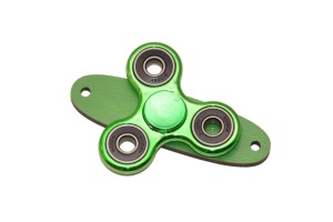 Zielony spinner do tablicy sensorycznej na zielonej podstawce.     