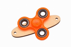 Pomarańczowy z brokatem spinner na podstawce do tablicy manipulacyjnej.  