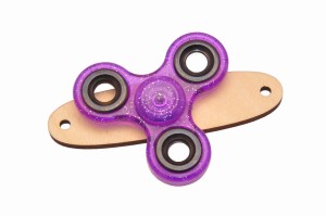 Fioletowy z brokatem spinner na podstawce do tablicy manipulacyjnej.   