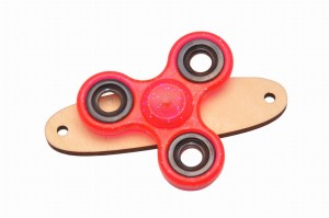 Czerwony z brokatem spinner na podstawce do tablicy manipulacyjnej.    